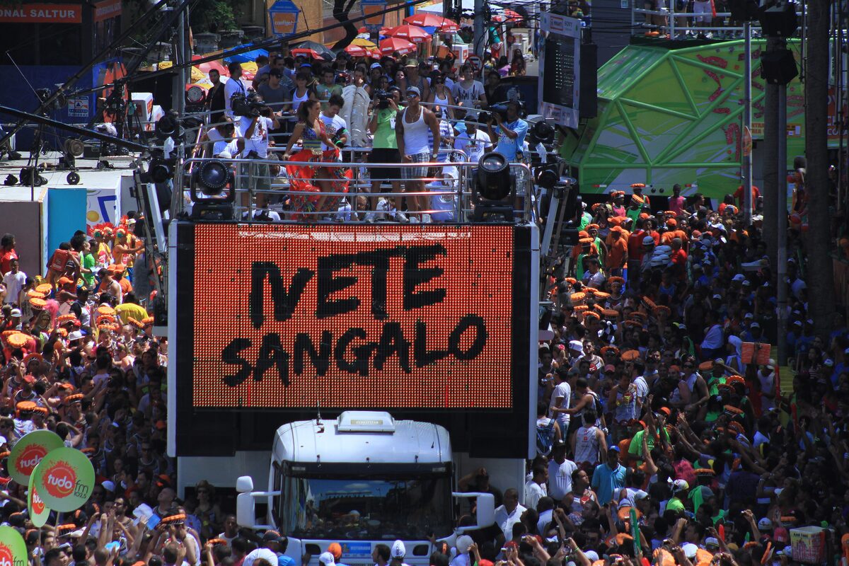 A trio elétrico with a large LED panel reading Ivete Sangalo, surrounded by a dense Carnival crowd