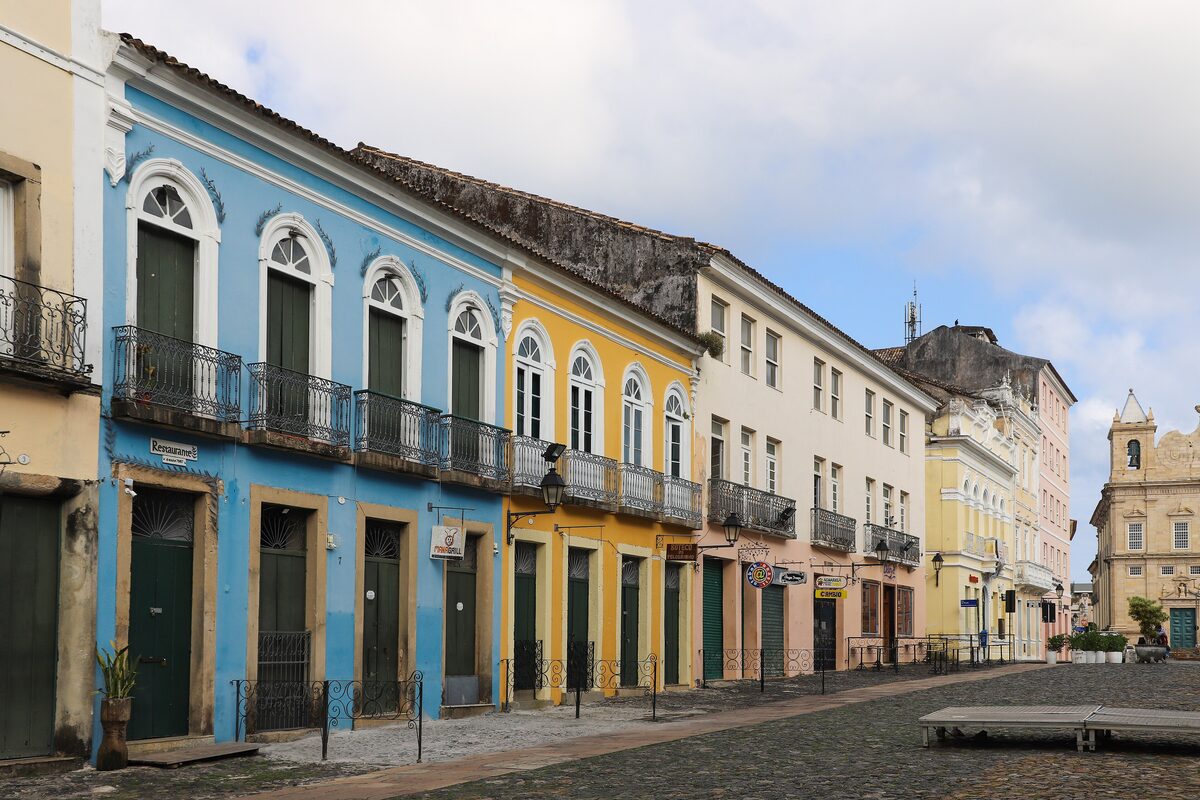 Colorful colonial houses on a cobbled square in Pelourinho, with blue and yellow facades