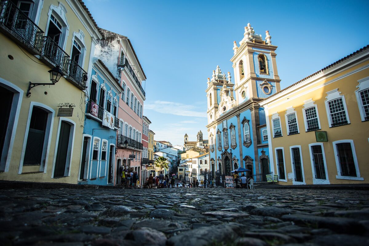 The blue-fronted Church of Our Lady of the Rosary of the Black Men with its twin towers, at the top of a cobbled street lined with yellow houses