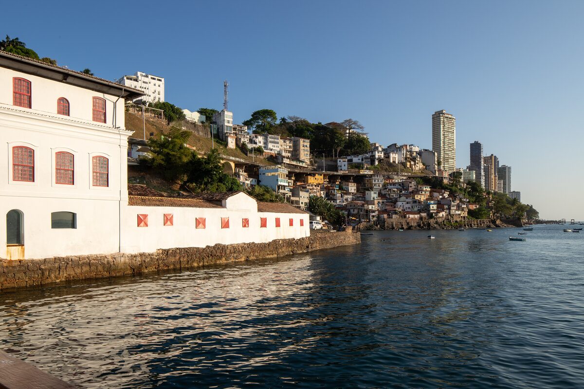 The bay from the Solar do Unhão: a white colonial building on the waterfront and hillside houses across the calm water