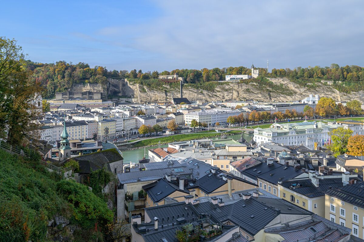 View from the Kapuzinerberg over the domes and spires of Salzburg's old town, with the cliffs of the Mönchsberg behind