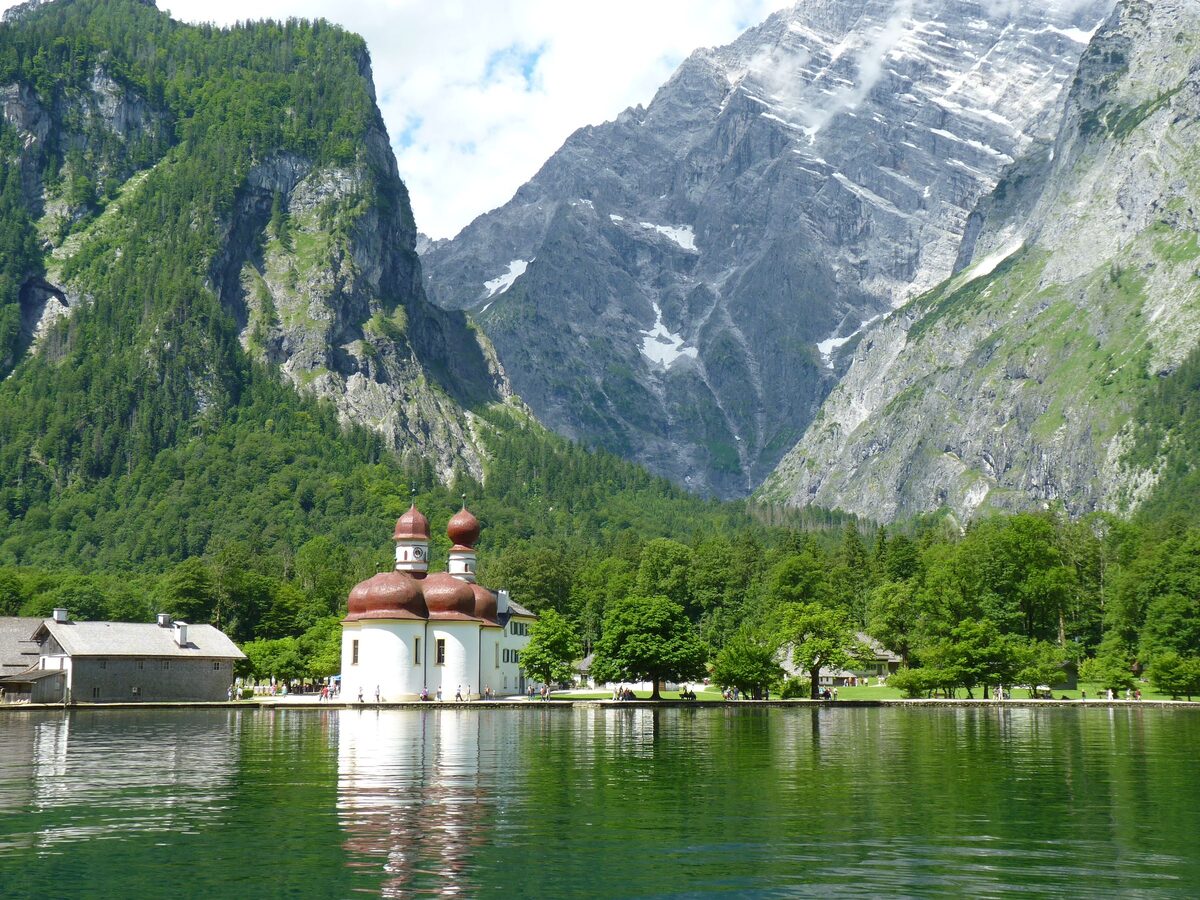 The red onion domes of St. Bartholomä on the shore of the Königssee, under the steep rock face of the Watzmann