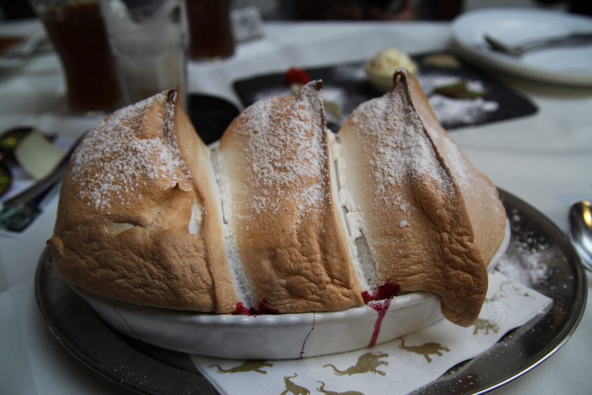 A golden Salzburger Nockerl, three peaks of baked meringue dusted with sugar, on a dish