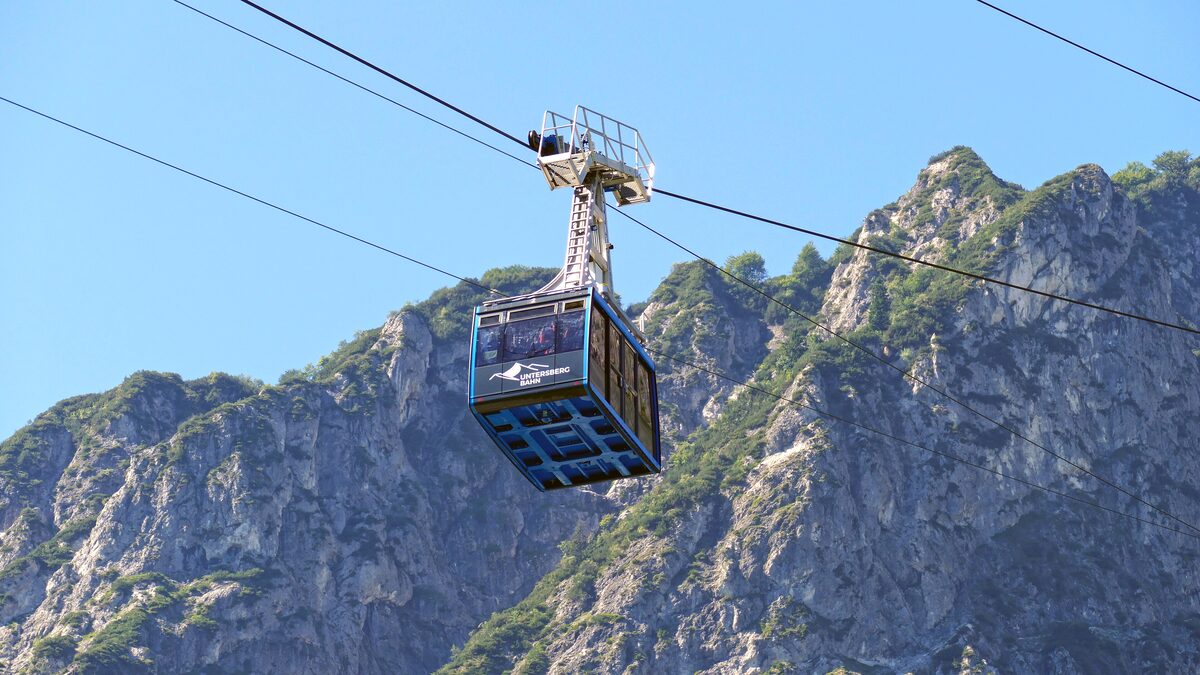 A cable car cabin of the Untersberg cable car climbing past steep limestone cliffs