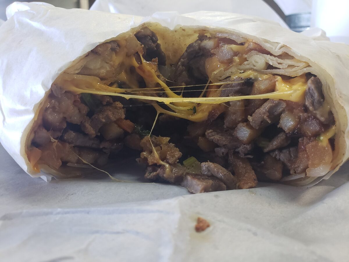 A California burrito cut open to show carne asada, fries and cheese