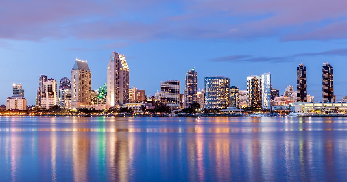San Diego's downtown skyline glowing at dusk across the bay, seen from Coronado
