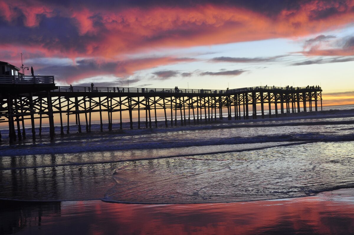 Crystal Pier silhouetted against a red sunset sky at Pacific Beach