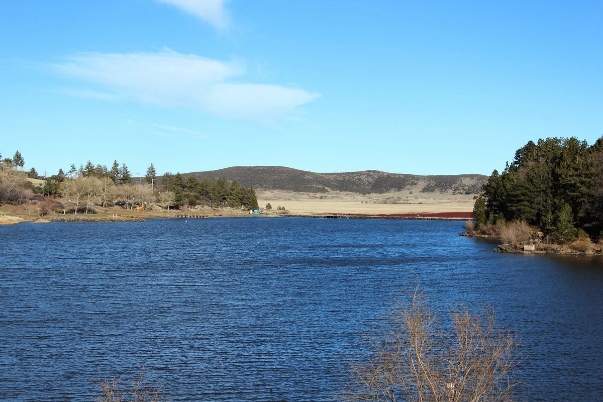 Lake Cuyamaca's blue water and golden meadow in the mountains
