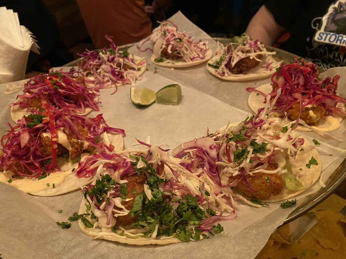 Fried fish tacos topped with purple cabbage and a lime wedge