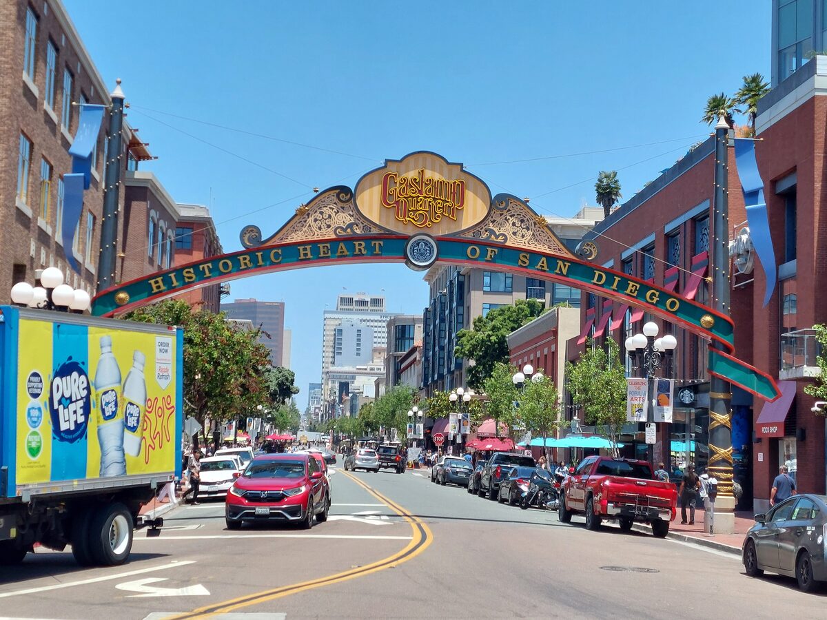 The Gaslamp Quarter arch over a sunny street lined with brick buildings