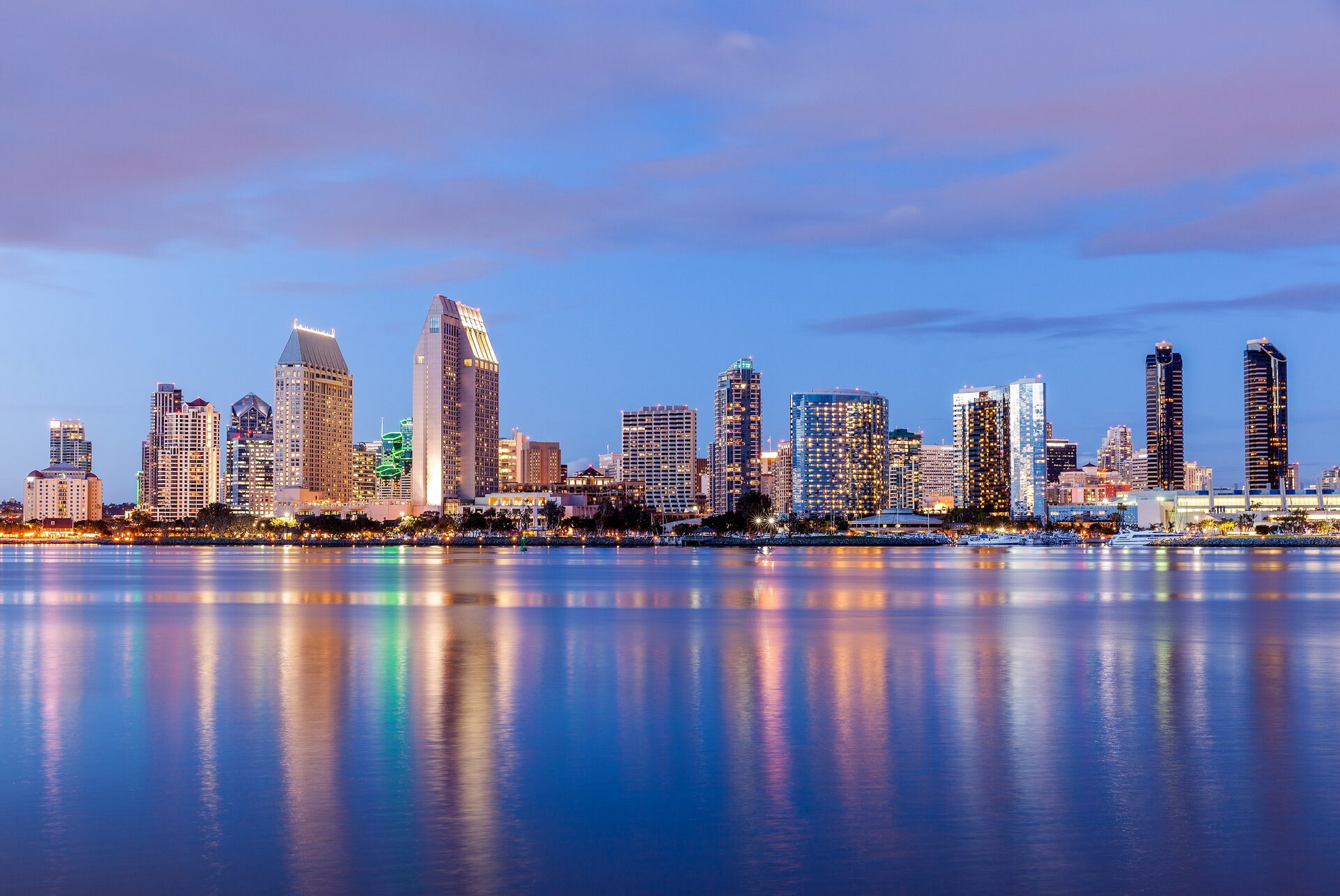 San Diego's downtown skyline glowing at dusk across the bay, seen from Coronado