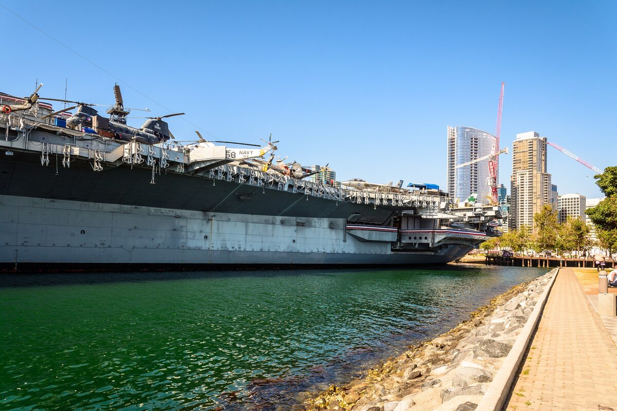 The USS Midway carrier moored along the Embarcadero beside downtown towers