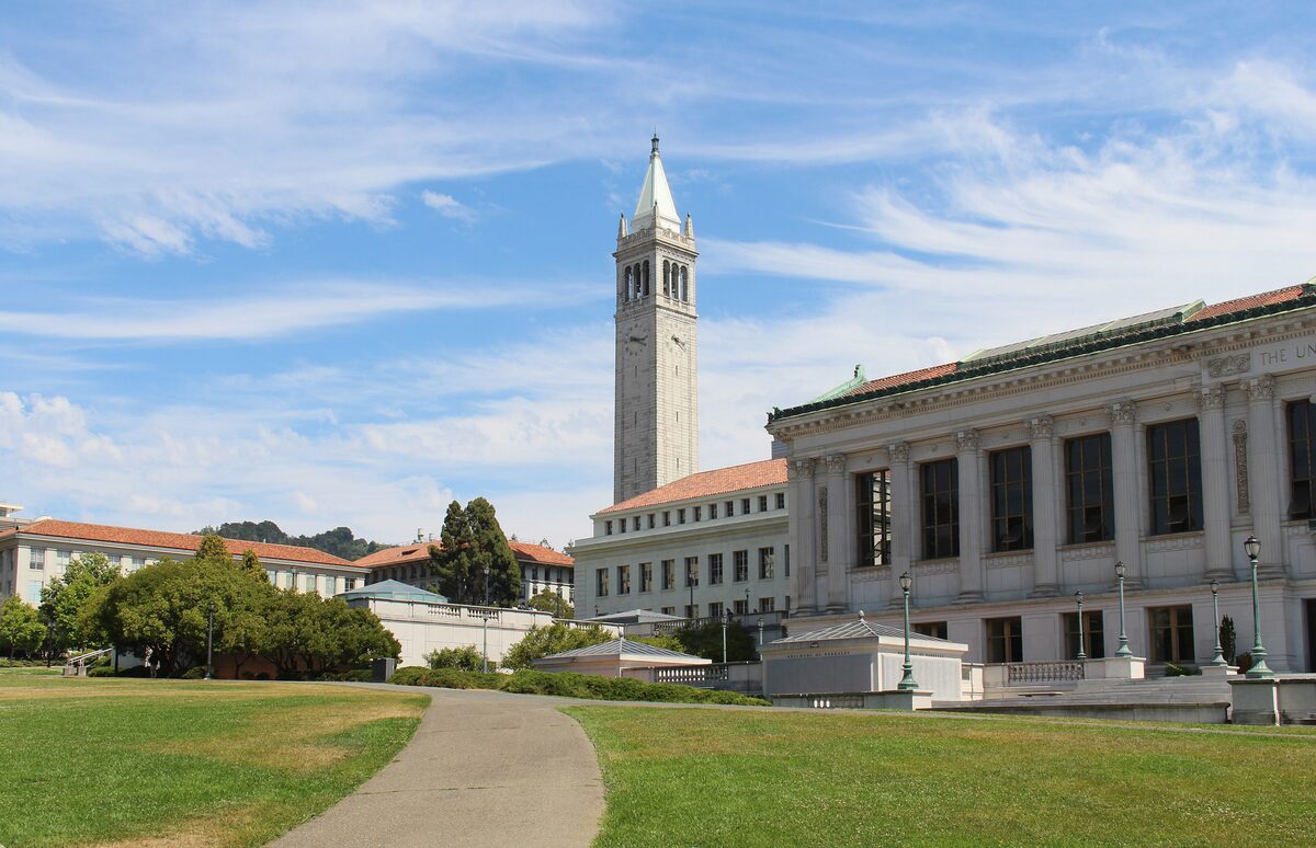 Sather Tower, the campanile of UC Berkeley, rising above the lawns and a library building