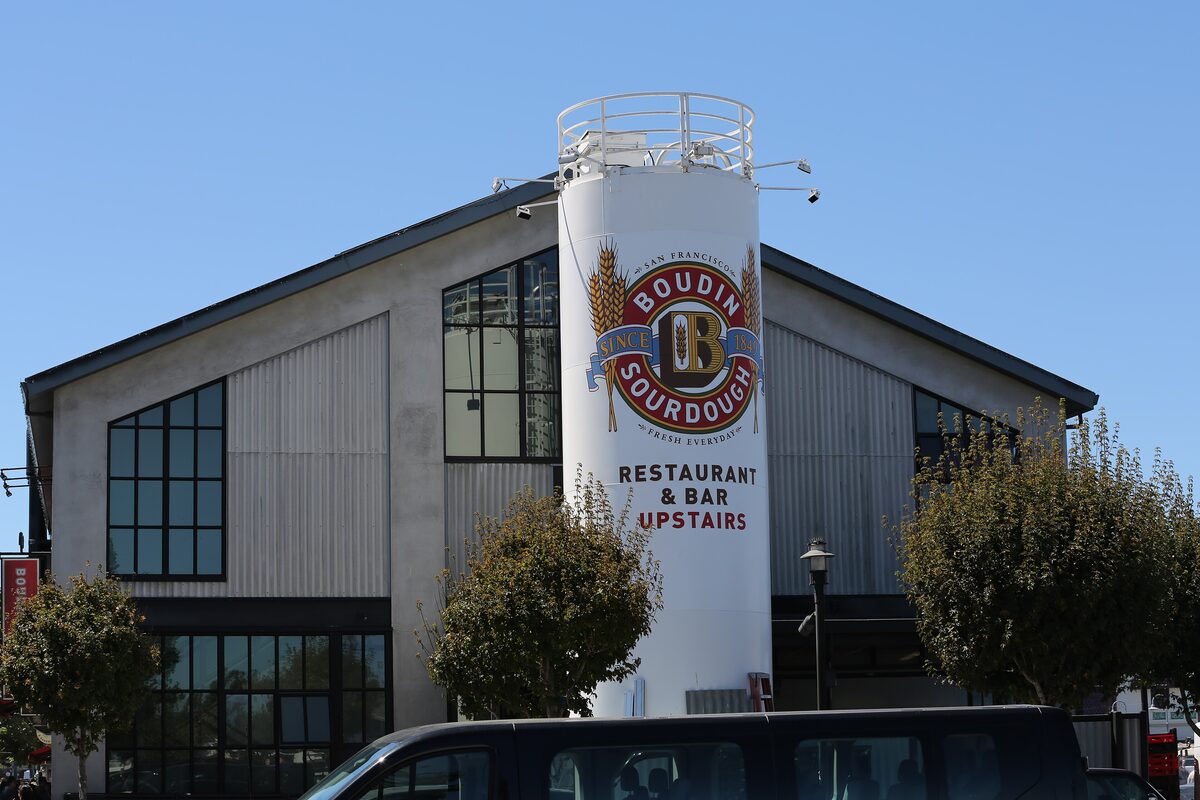The Boudin Bakery building on Fisherman's Wharf, with the tall white Boudin Sourdough silo sign against a blue sky