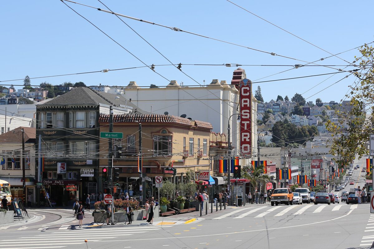 The Castro Theatre's vertical neon sign above Castro Street, with rainbow flags along the street