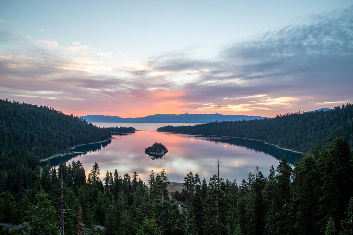 Emerald Bay and its small island on Lake Tahoe, ringed by pine forest at sunset