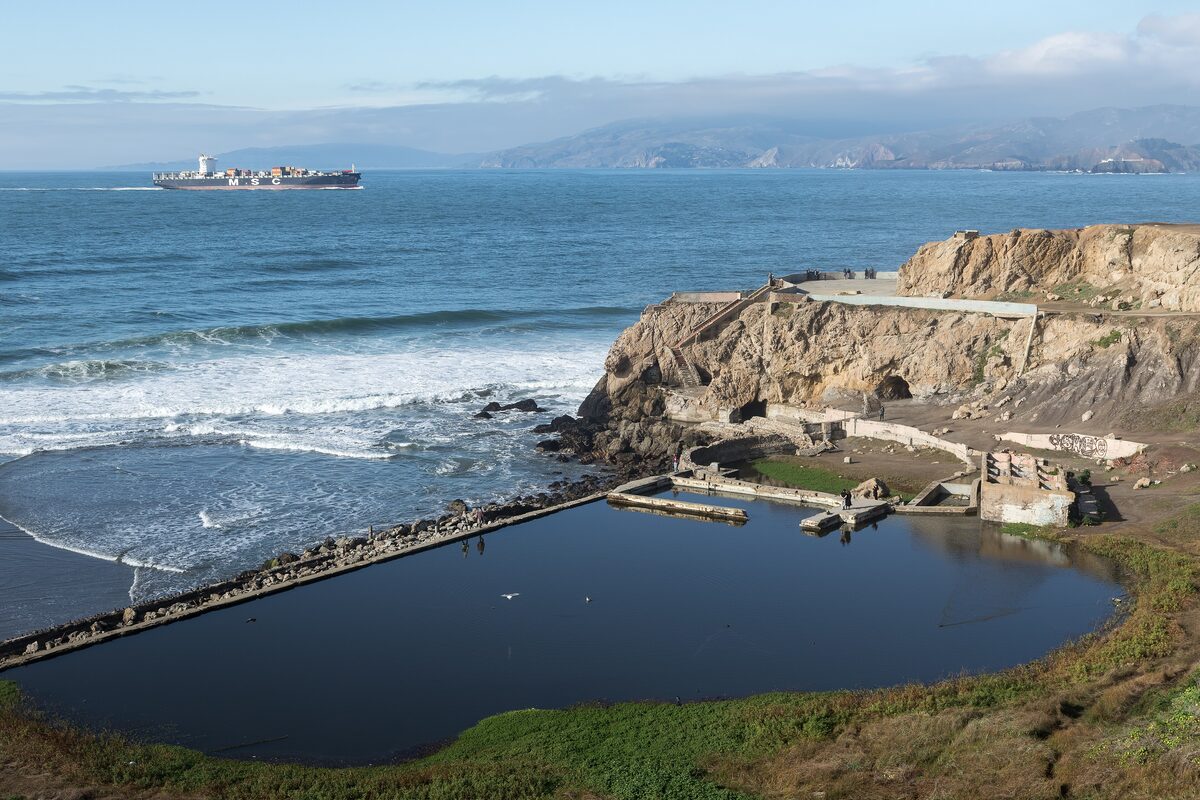 The ruined Sutro Baths pools and rocky shore at Lands End, with the Golden Gate in the far distance