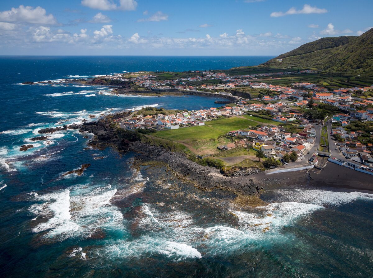 Aerial view of Mosteiros village on its black rocky headland, with surf breaking on the northwest coast