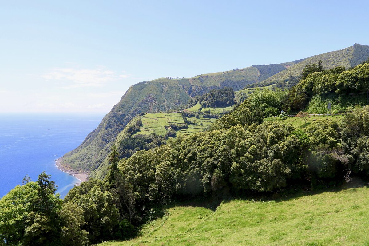 Green slopes falling to the sea and a cove at Ponta do Sossego on the northeast coast