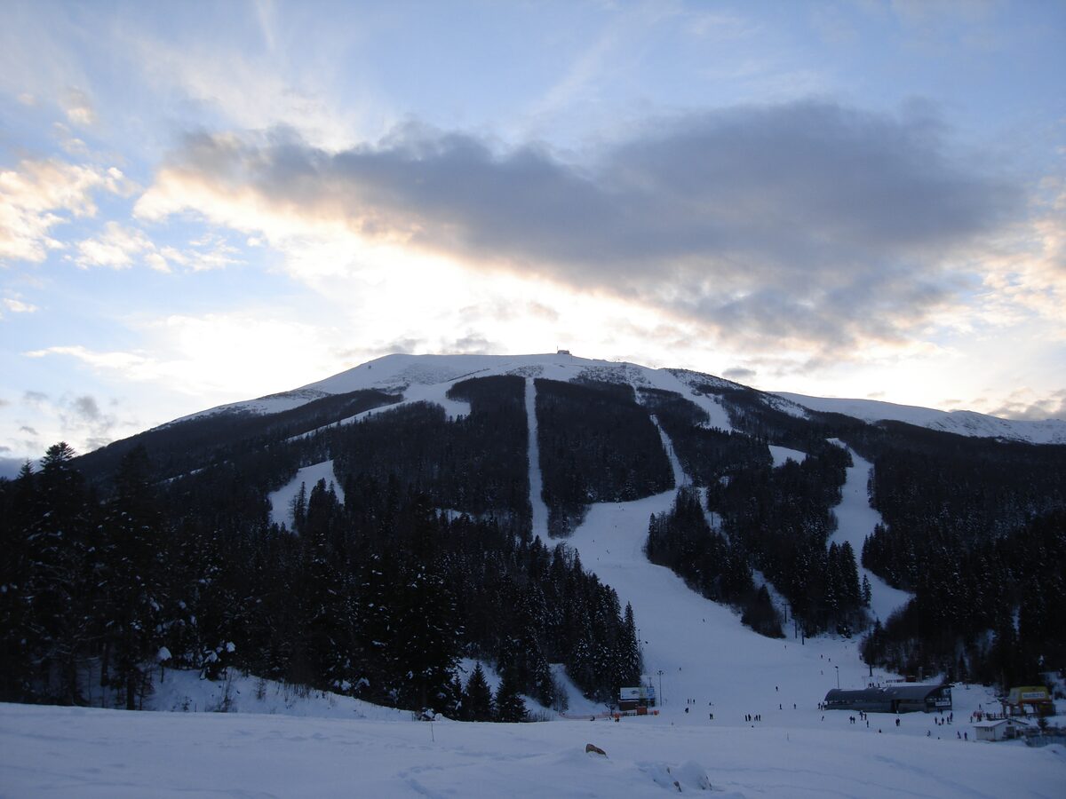 The snowy slopes of Bjelašnica above the Babin Do base, with pistes cut through dark forest up to the summit ridge