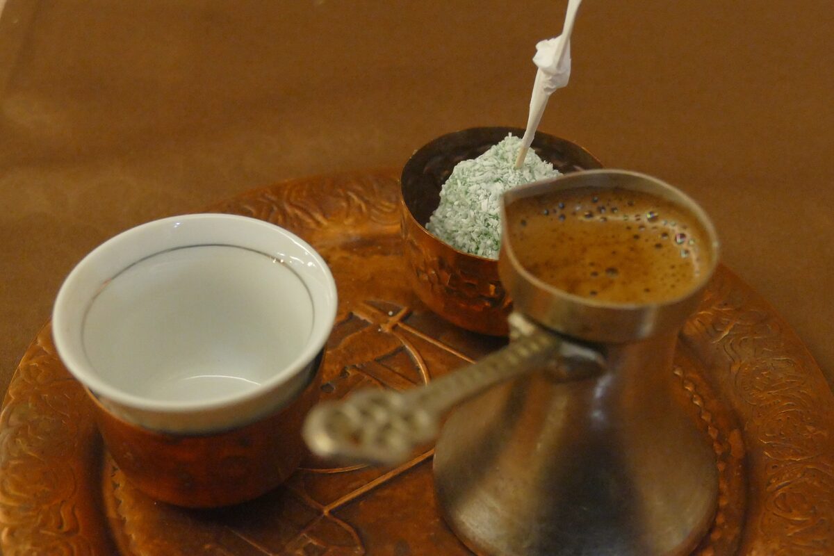 Bosnian coffee in a copper džezva beside a small cup on a copper tray