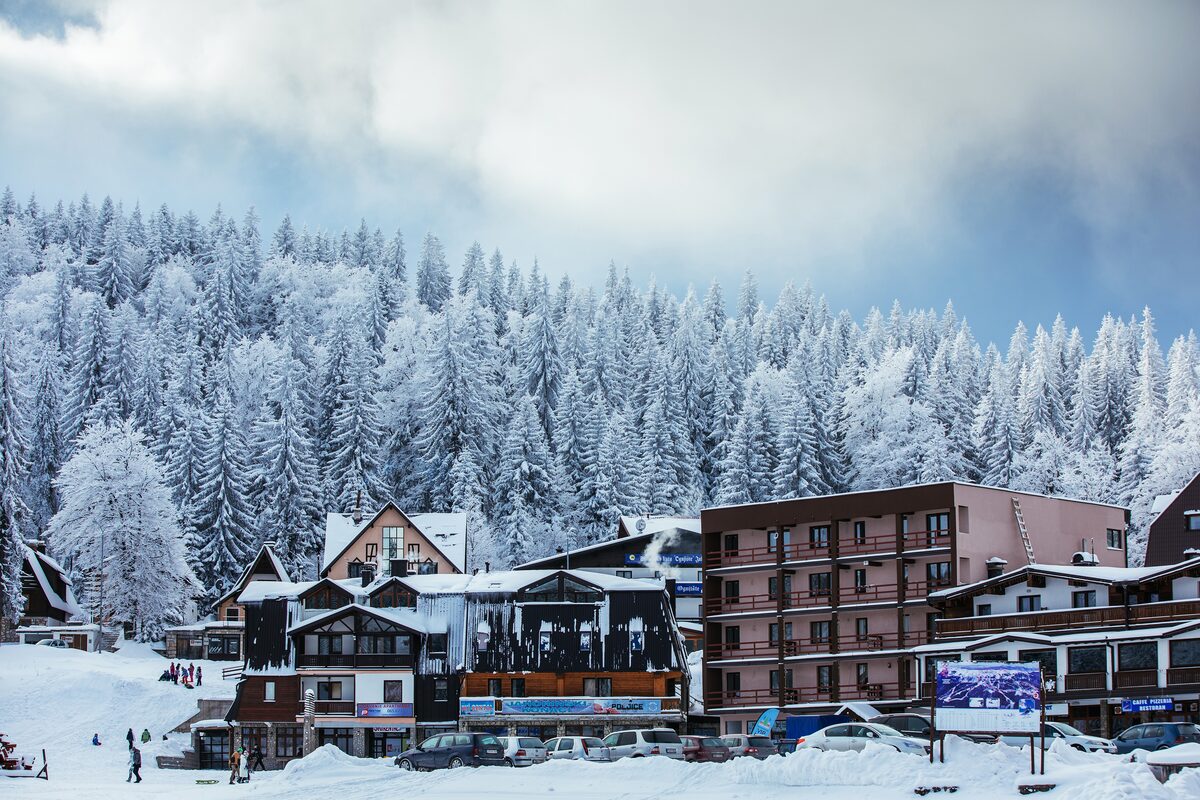 The village of Jahorina in winter, hotels and chalets under deep snow below the spruce forest