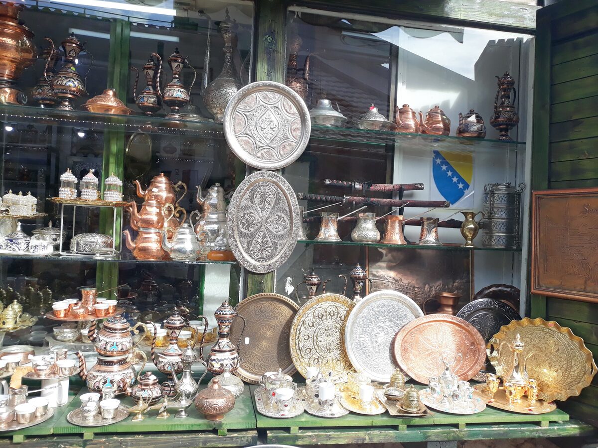 A coppersmith's shop window in Kazandžiluk, full of hammered copper trays, džezvas and coffee sets