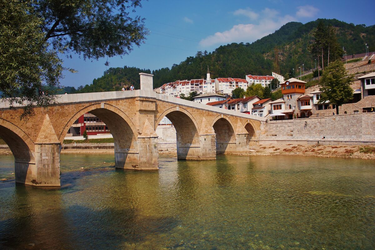 The old stone arch bridge over the Neretva at Konjic, with the town on the hillside beyond