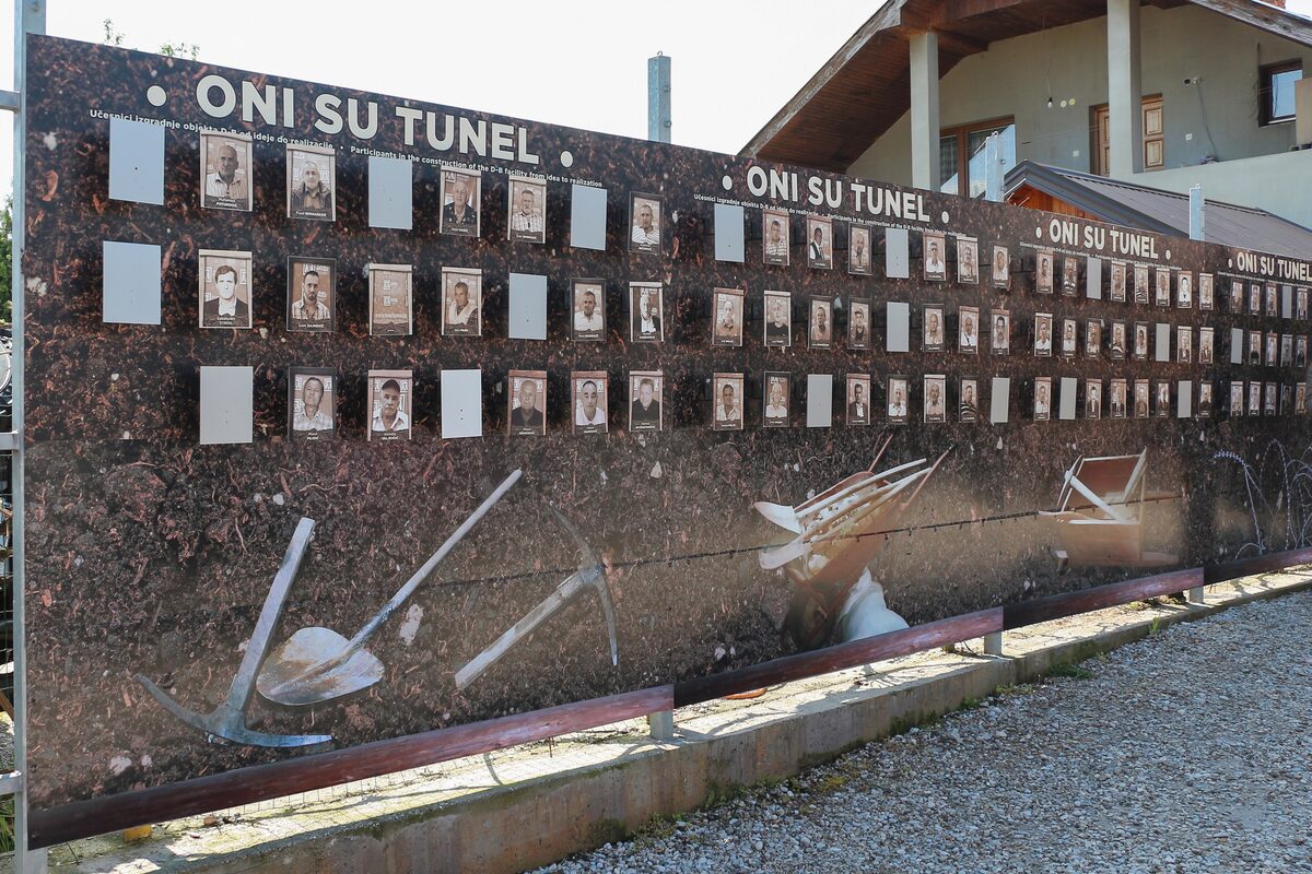 The outside wall of the Sarajevo War Tunnel museum, covered with portrait photographs and the words ONI SU TUNEL