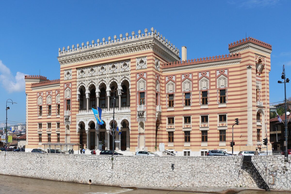 The neo-Moorish City Hall with its striped red and cream stone facade above the Miljacka embankment