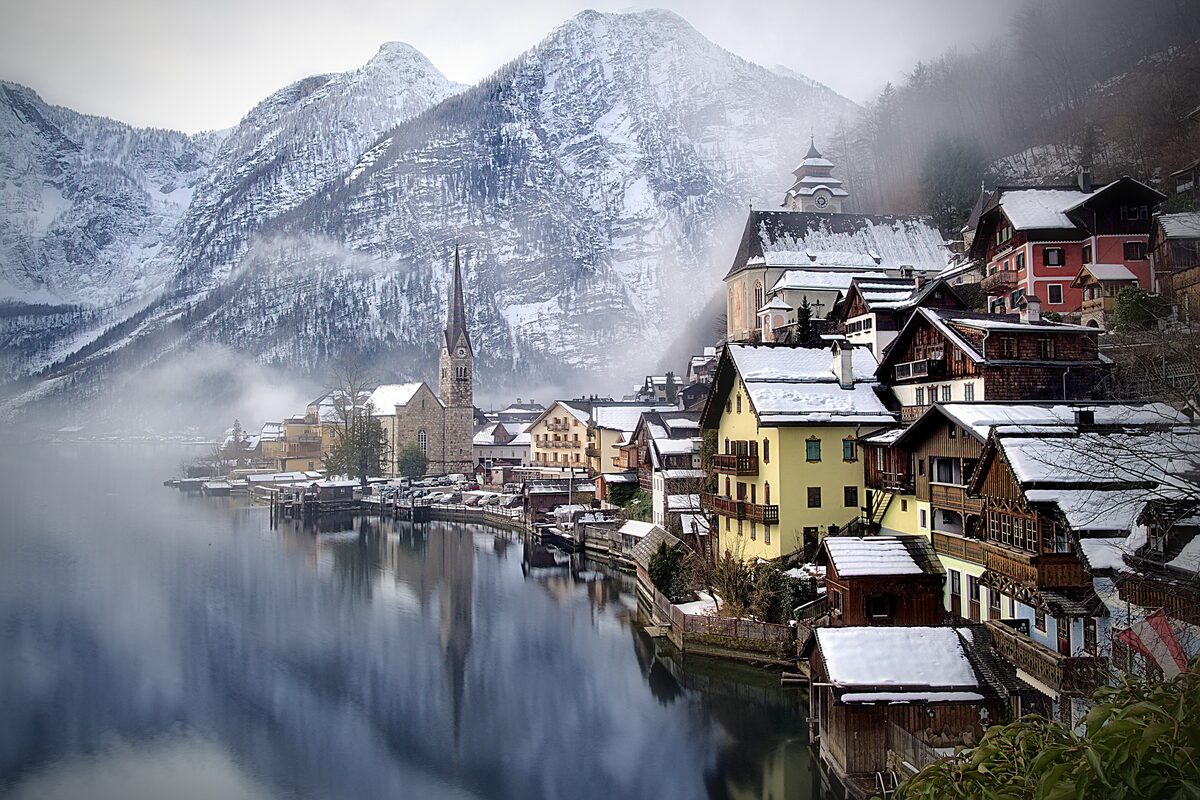 Hallstatt in winter, with snow on the roofs and the lake under a light mist