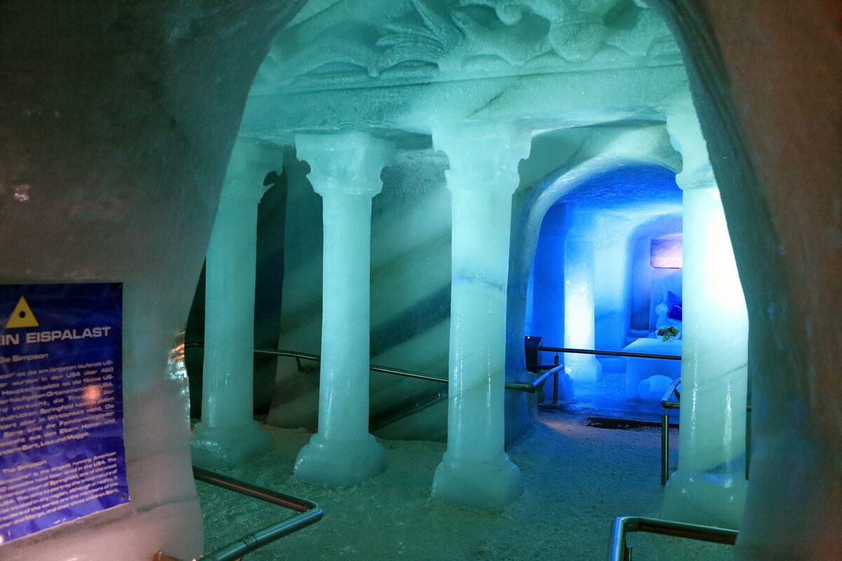 Ice columns and a corridor lit in blue inside the Ice Palace on the Dachstein glacier