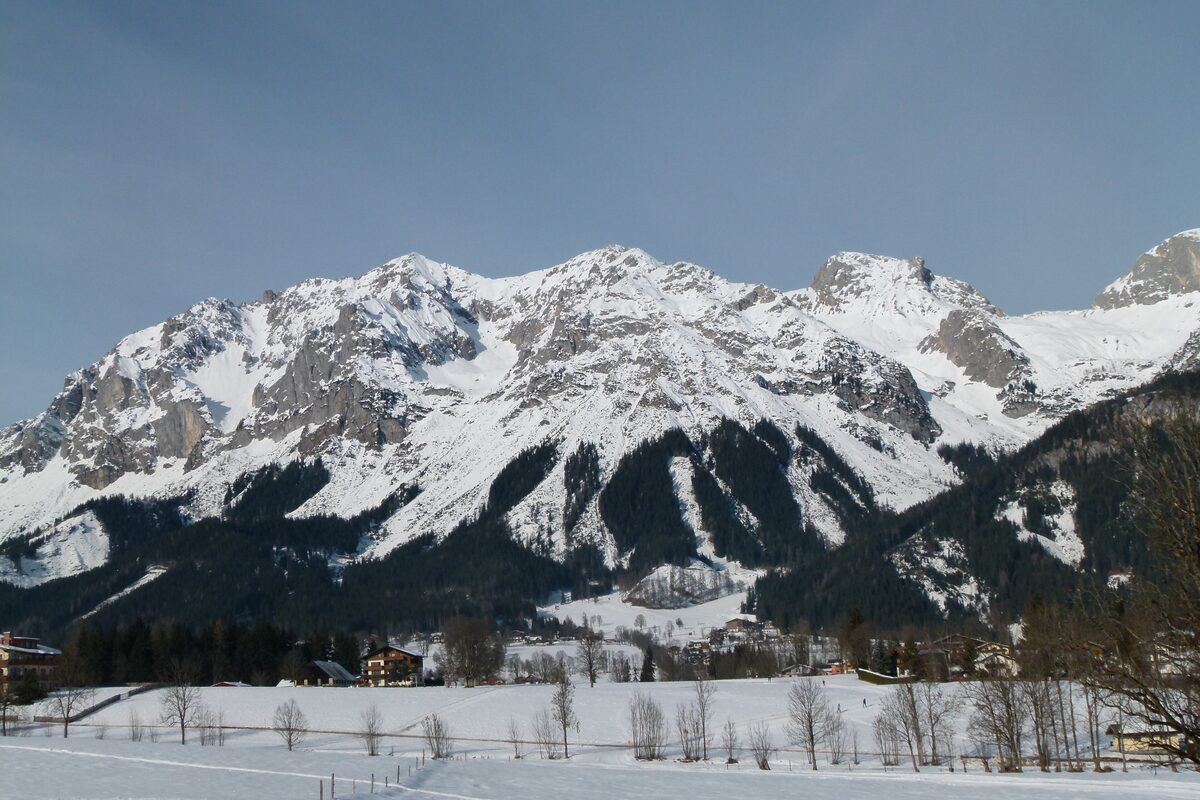 Snowy meadows in Ramsau am Dachstein with the south face of the Dachstein rising above the village