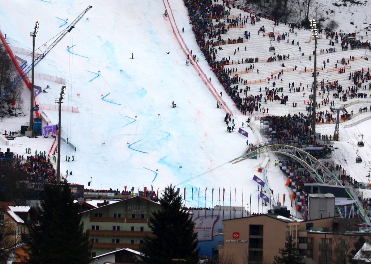 The Planai finish stadium during the 2013 World Championships, with the race slope, crowded grandstands and the light arch above the finish line