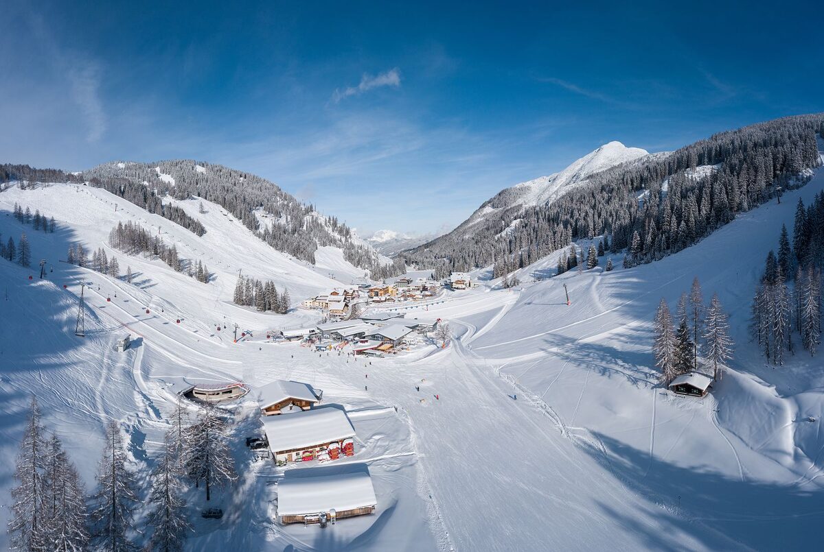 Snowy slopes and chalets at the Zauchensee in Altenmarkt under a blue winter sky