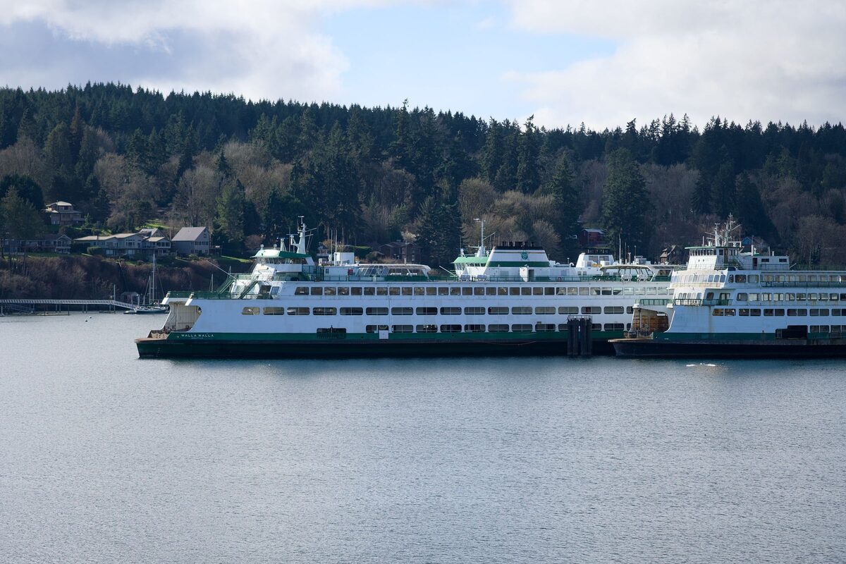 A Washington State ferry crossing Puget Sound beside forested hills