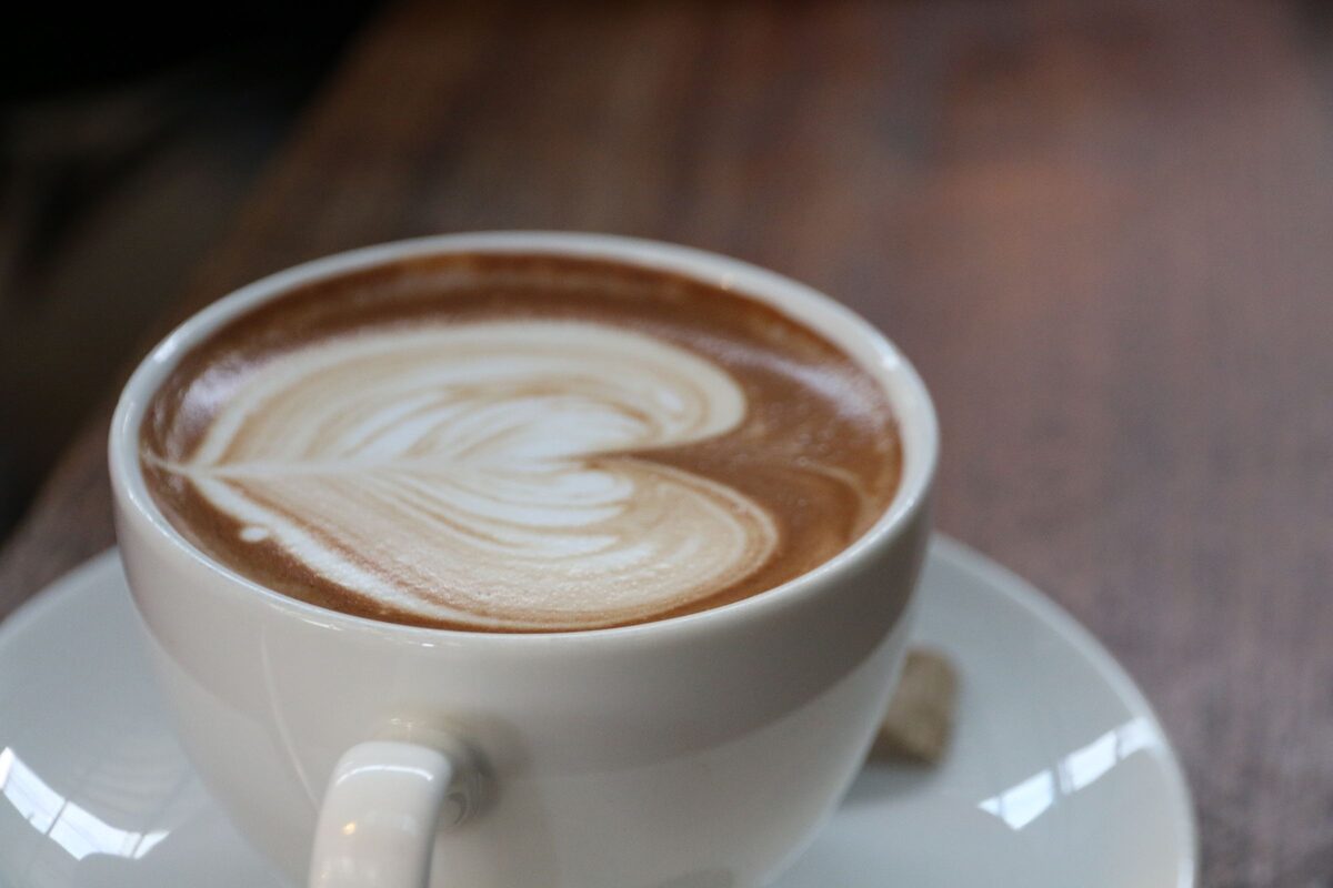 A latte with heart-shaped foam art on a saucer