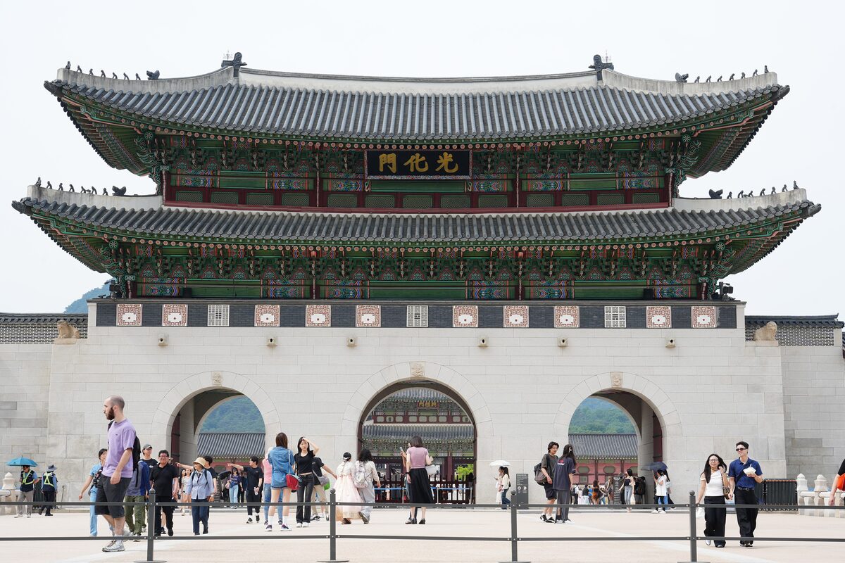Gwanghwamun, the two-storey main gate of Gyeongbokgung, with visitors gathered in front of its stone base