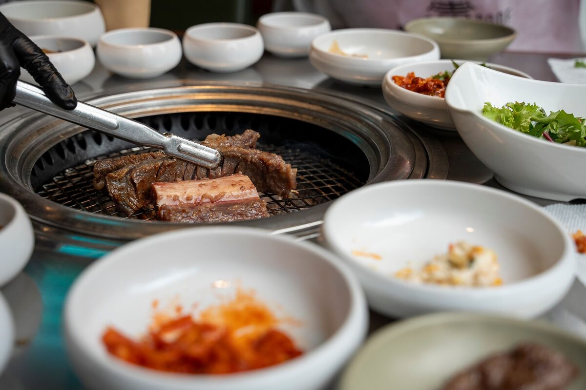 Short ribs on a table grill in a Seoul restaurant, surrounded by bowls of side dishes