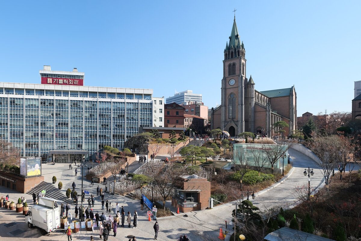 Myeongdong Cathedral with its tall Gothic bell tower rising above the hill and the street below