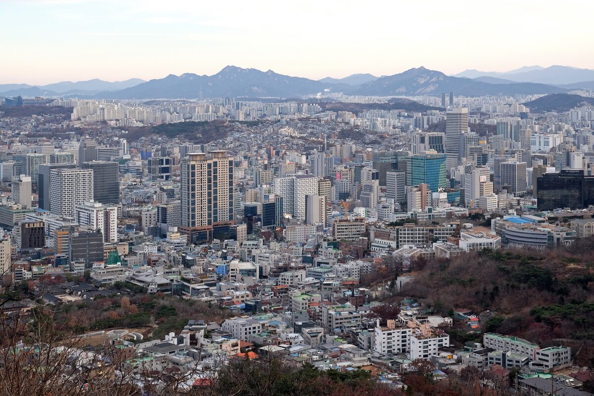 View over Seoul's dense city blocks from the slopes of Namsan, with mountains on the horizon