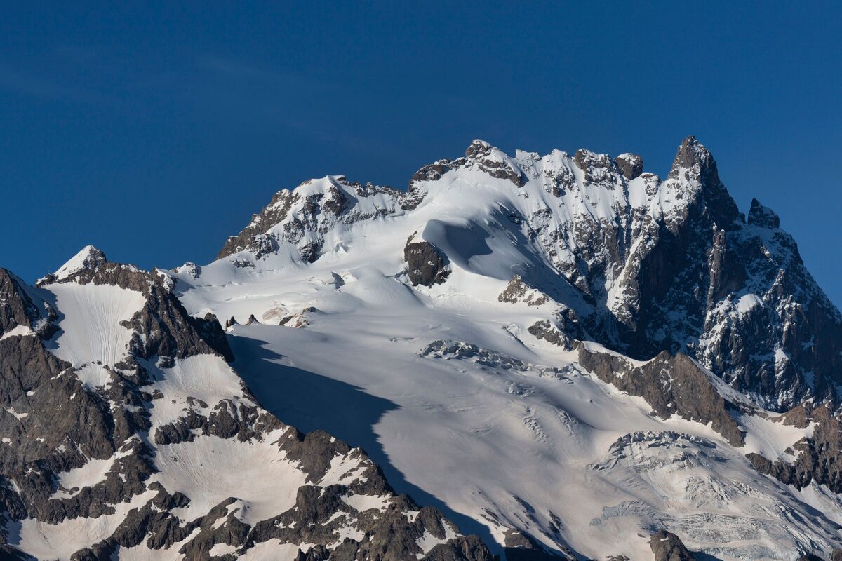 The snowy summit and glacier of La Meije, the peak above La Grave, under a deep blue sky