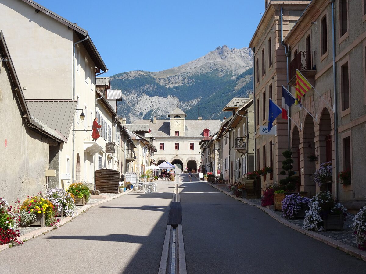 A street in Mont-Dauphin with flower boxes and the arch of the fortified gate at the end