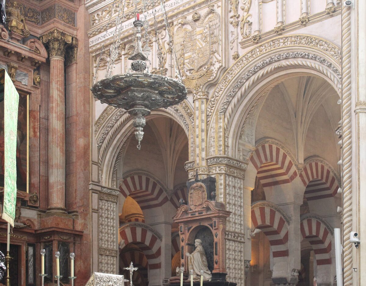Inside the Mezquita of Córdoba, where a Renaissance chapel rises among the striped red and white horseshoe arches of the old mosque