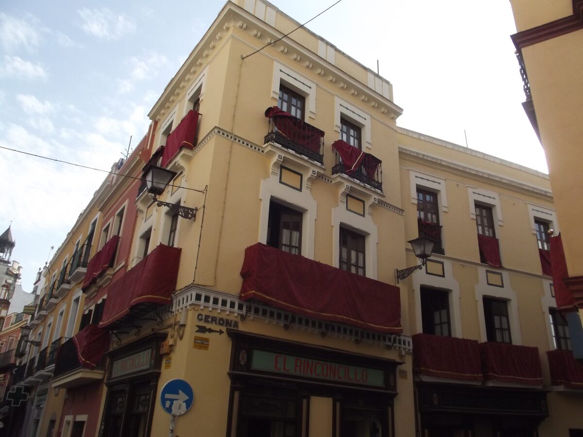 The corner building of El Rinconcillo in Seville, a yellow facade with red awnings and old wooden balconies