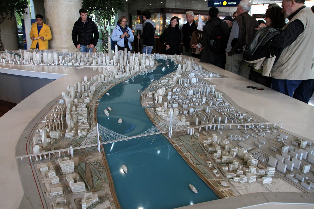 Visitors gathered around the large scale model of central Shanghai, with the blue Huangpu River running through it