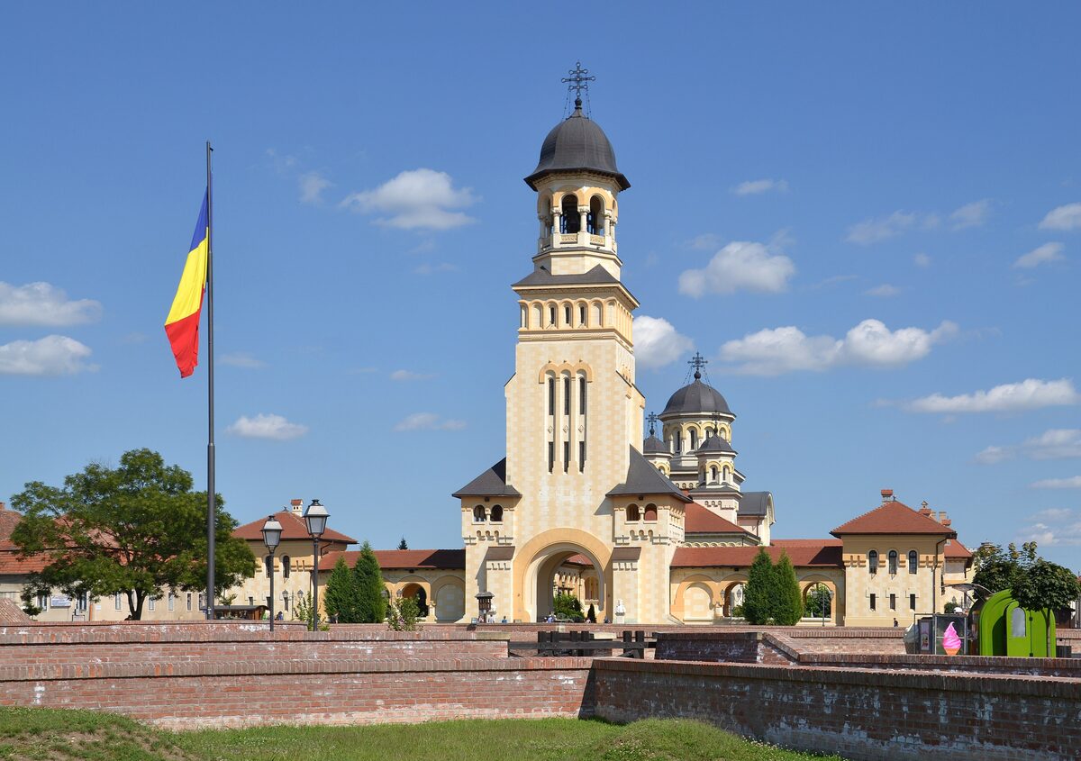 The bell tower and domes of the Coronation Cathedral inside the Alba Carolina citadel, behind the brick ramparts