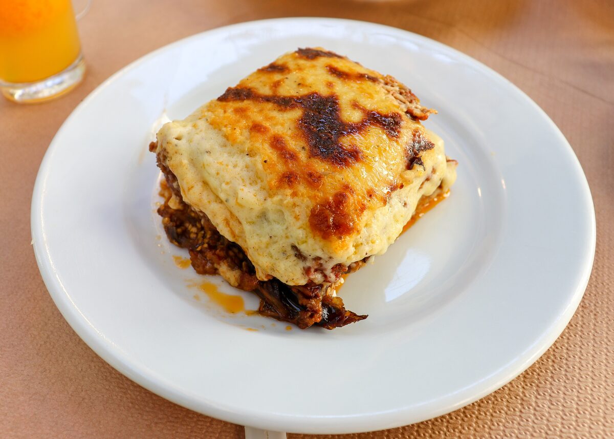 A square of moussaka with a browned top on a white plate