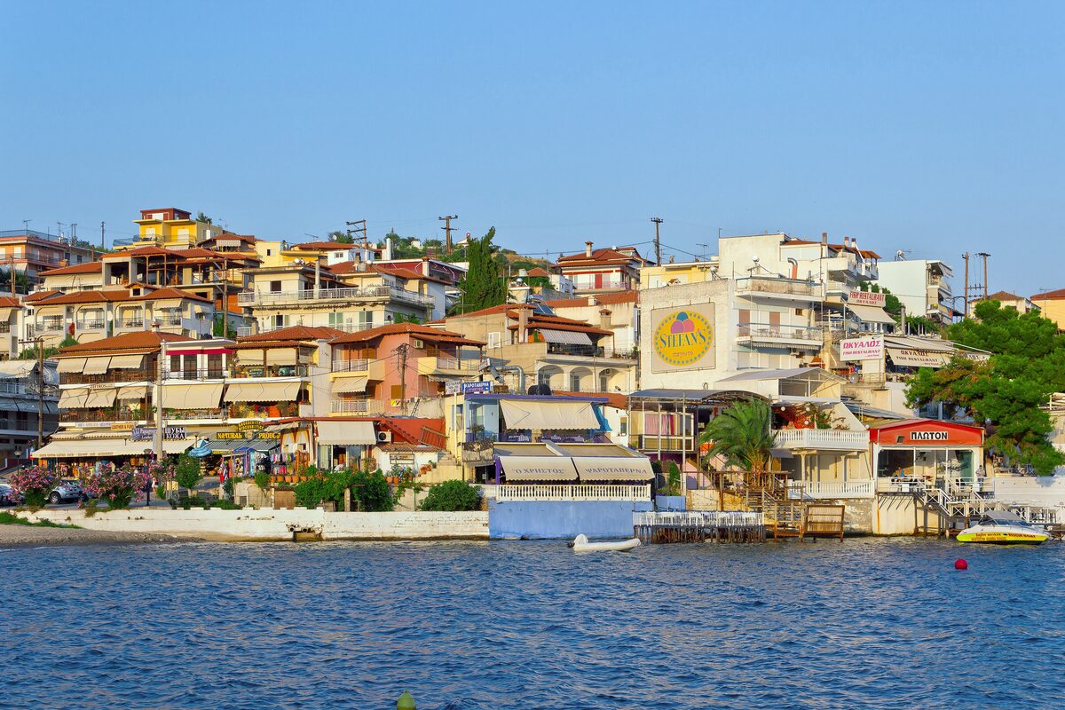 Town houses and waterfront buildings along the bay of Neos Marmaras, with boats on the water