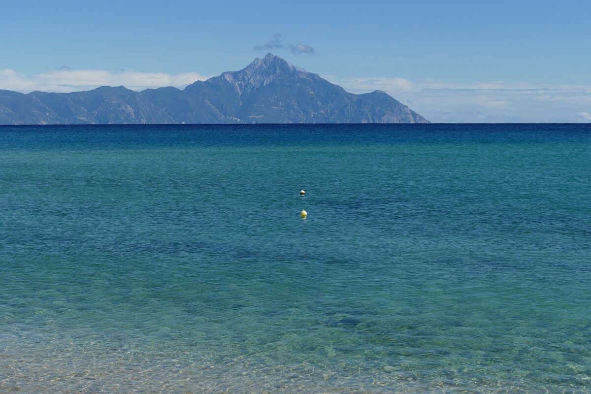 Clear green sea off Sarti with Mount Athos rising across the water